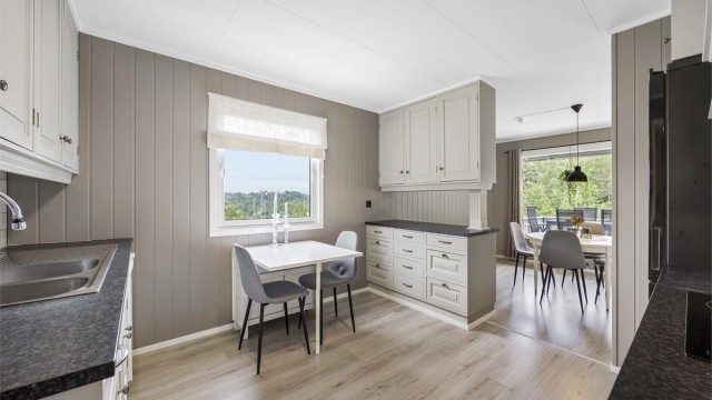 Kjøkkenet har profilerte fronter, laminert benkeplate og plass til spisebord.