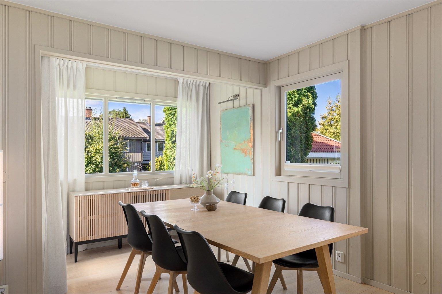 Spisestuen ligger i den innbygde verandadelen fra 2004 med vinduer på to sider samt terrassedør i tillegg