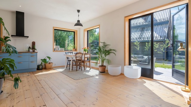 Stue og kjøkkenet har store vinduer som slipper inn mye naturlig lys.