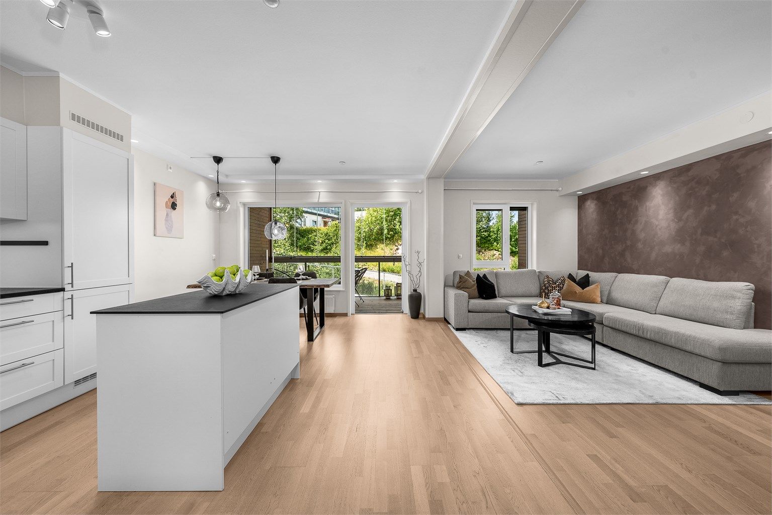 Stuen ligger i åpen løsning mot kjøkkenet, som har en moderne og tidsløs innredning, med integrerte hvitevarer som medfølger handelen. 