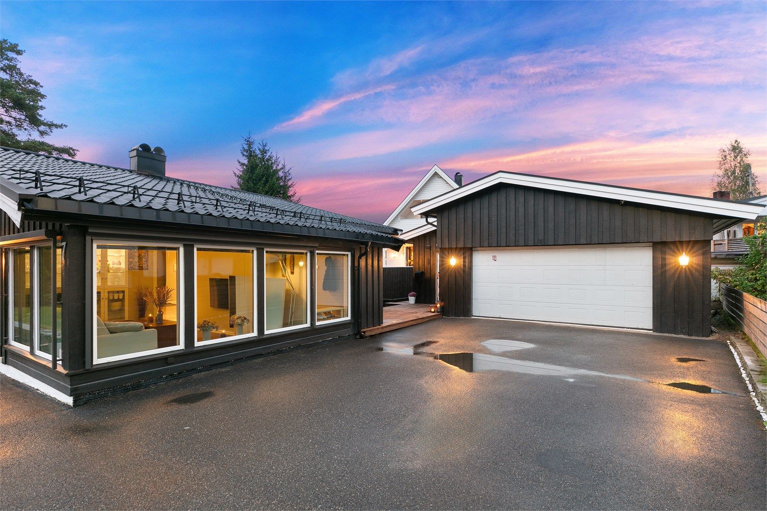 Stor asfaltert gårdsplass og praktisk dobbelgarasje gir enkel hverdagslogistikk.