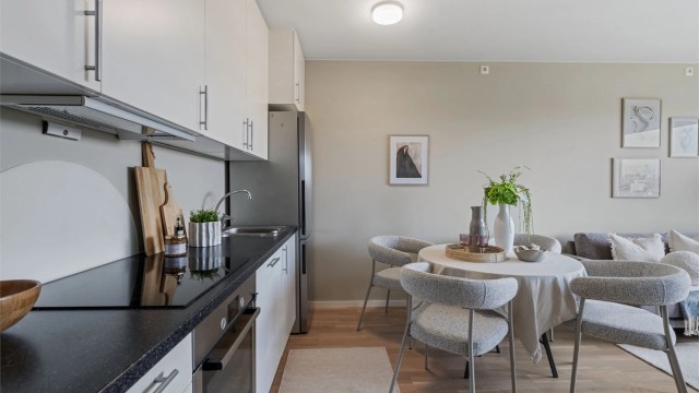 Kjøkkeninnredning fra byggeåret med glatte fronter og en slitesterk laminatbenkeplate.
