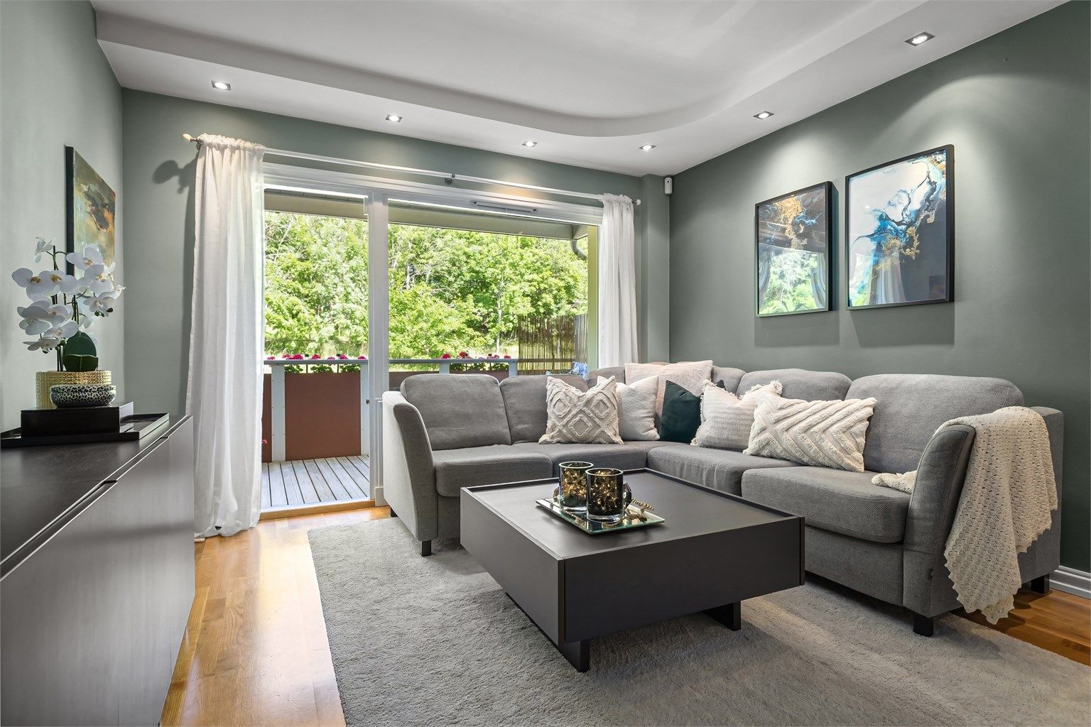 Stuen har downlights i taket og parkettgulv, som gir et lyst, moderne og innbydende uttrykk.