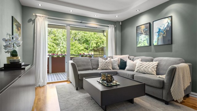 Stuen har downlights i taket og parkettgulv, som gir et lyst, moderne og innbydende uttrykk.