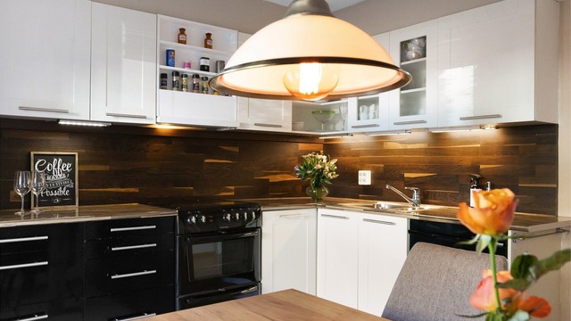 Kjøkkenet har komfyr, oppvaskmaskin og kjøleskap med fryser