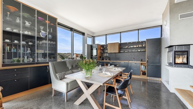 Kjøkkenet er utstyrt med plassbygget innredning med glatte fronter, benkeplate av heltre, integrert kjøleskap, oppvaskmaskin, platetopp og stekeovn, samt kjøkkenventilator med avtrekk ut