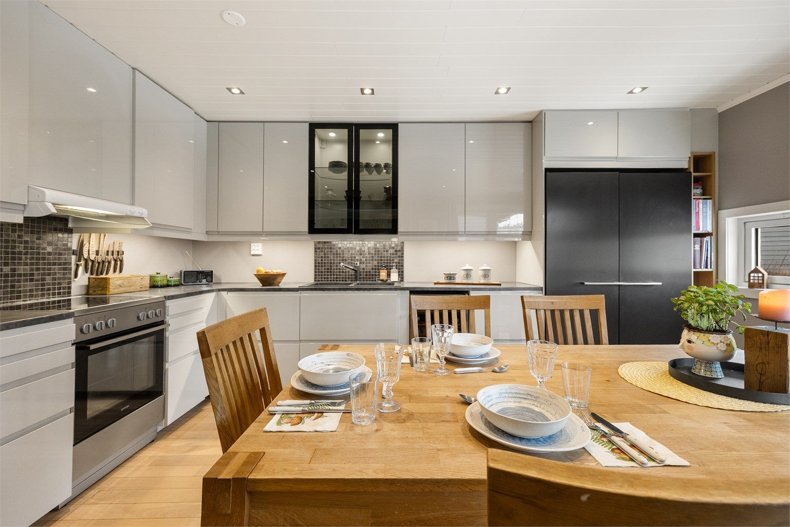 Kjøkkenet har en moderne innredning med slette fronter og nedsenket himling med downlights.