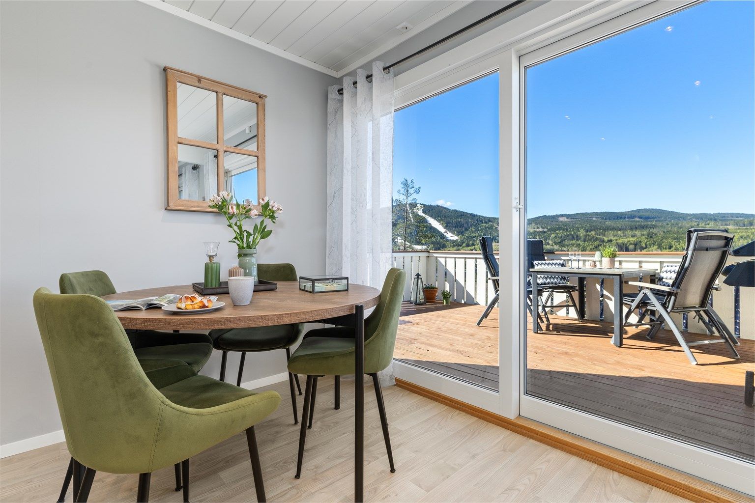 Stuen har en superfin skyvedør med store glassflater som gir masse lys inn inn i rommet og en fin åpning mot verandaen