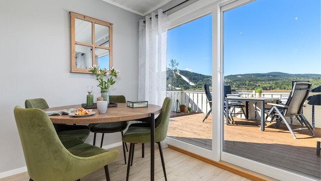 Stuen har en superfin skyvedør med store glassflater som gir masse lys inn inn i rommet og en fin åpning mot verandaen