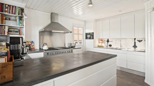 En robust benkeplate i betong og en bred gasskomfyr gjør kjøkkenet godt rustet for matlaging. I tilknytning til kjøkkenet ligger et praktisk kjølerom.