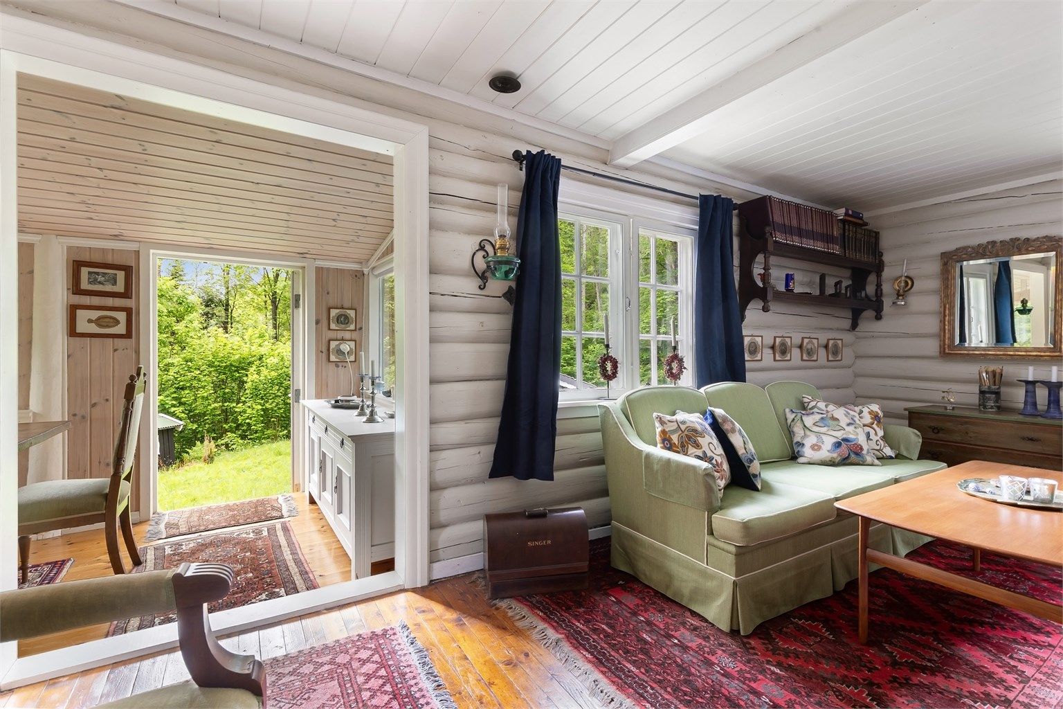 Fra stuen er det åpen tilgang til spisestuen, som med store vindusflater slipper naturen inn.