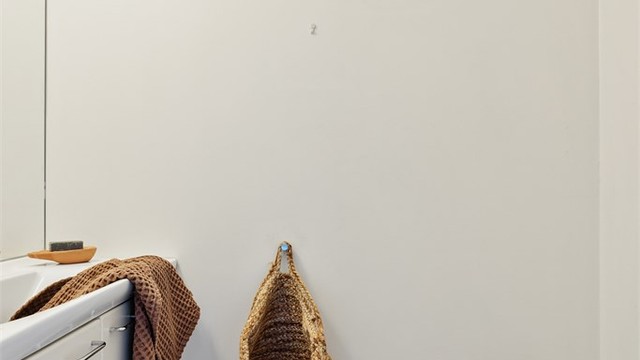 Toalettrom med gulvflate belagt med fliser. Malte veggflater. Malte flater i himling. Vegghengt servantinnredning. Vegghengt toalett. Mekanisk avtrekk med ventil i himling.