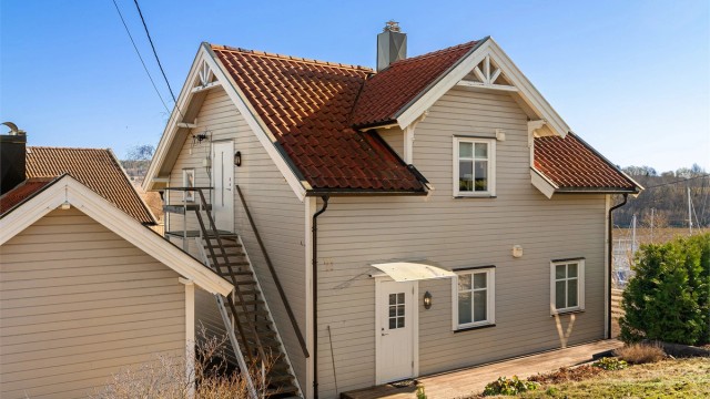 På plattingen foran inngangspartiet er det sommerstid sol fra ettermiddag til kveld. Baldakin ble montert over ytterdøren i 2024.