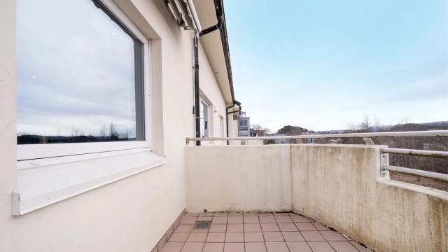 Balkongen har flislagt gulv og plass til en sittegruppe.