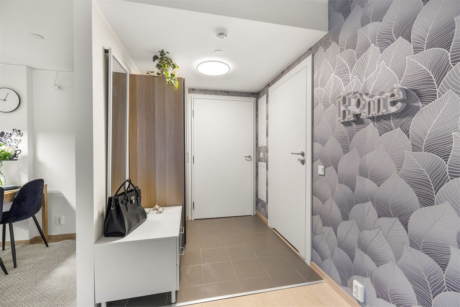 Entréen ønsker velkommen med flislagt gulv og behagelig vannbåren gulvvarme.