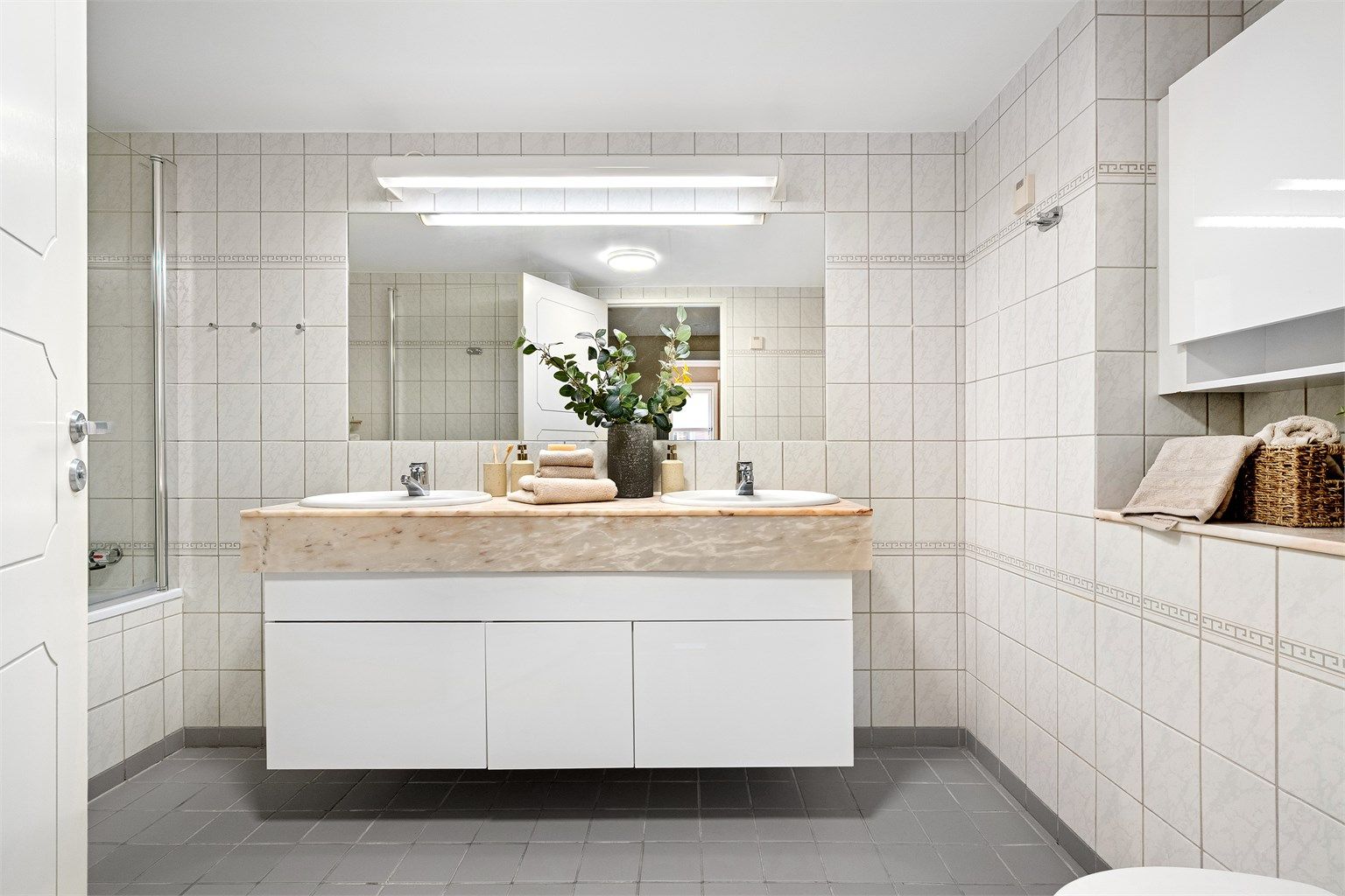 Romslig og stort helfliset bad med badekar, dobbelservant og toalett. 