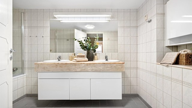 Romslig og stort helfliset bad med badekar, dobbelservant og toalett.