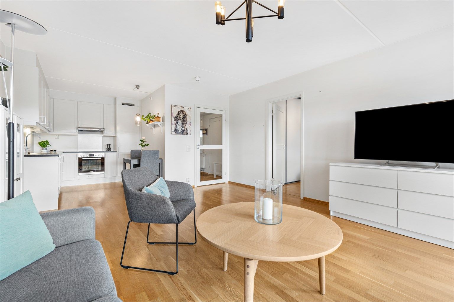 Stue med plass til sittegruppe og TV-område. Åpen løsning mellom stue og kjøkken.