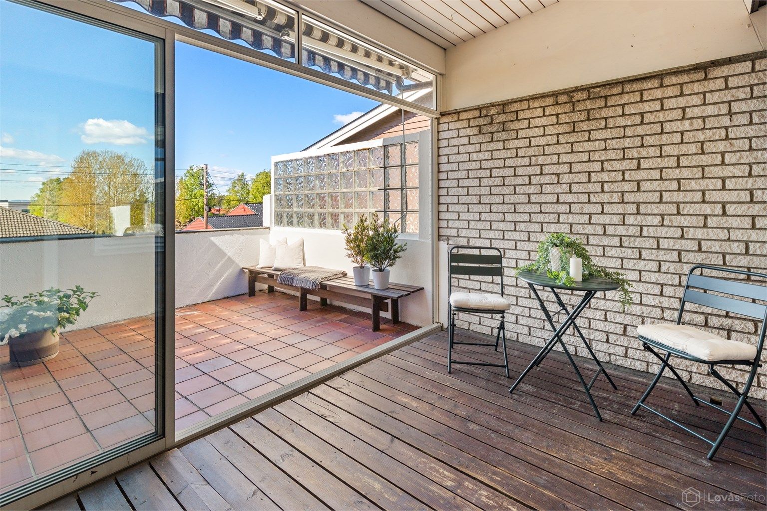 Utgang fra stuen/spisestuen til vestvendt og usjenert innglasset veranda på 10 kvm med skyvedører i glass ut mot åpen veranda på ytterligere 10 kvm