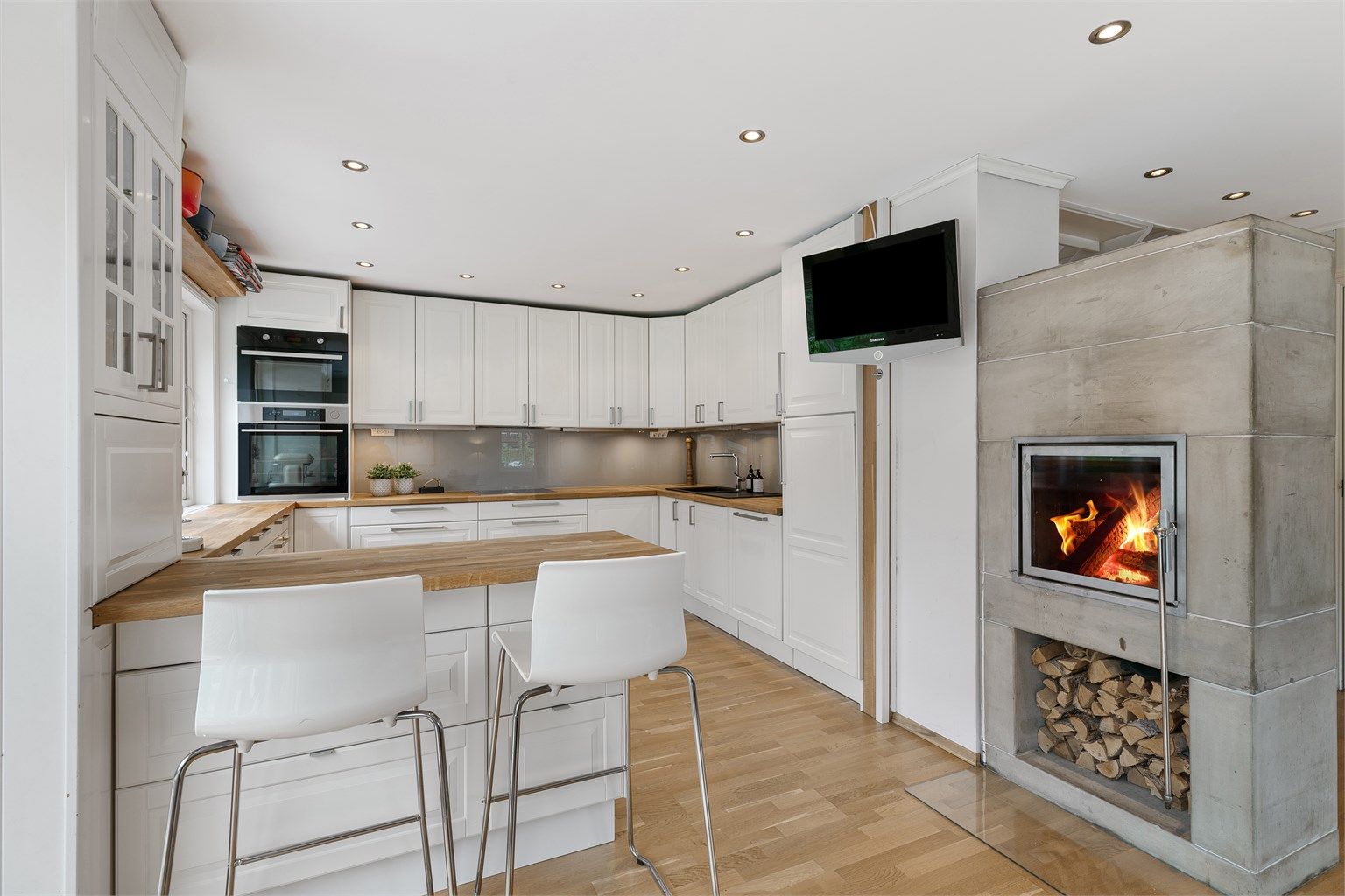 Kjøkkenet er lyst, sosialt og praktisk, med gode arbeidsflater, mye oppbevaring og en smart barløsning for familien