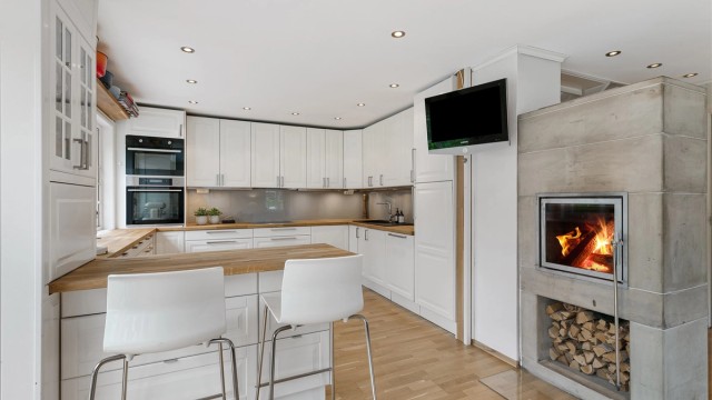 Kjøkkenet er lyst, sosialt og praktisk, med gode arbeidsflater, mye oppbevaring og en smart barløsning for familien