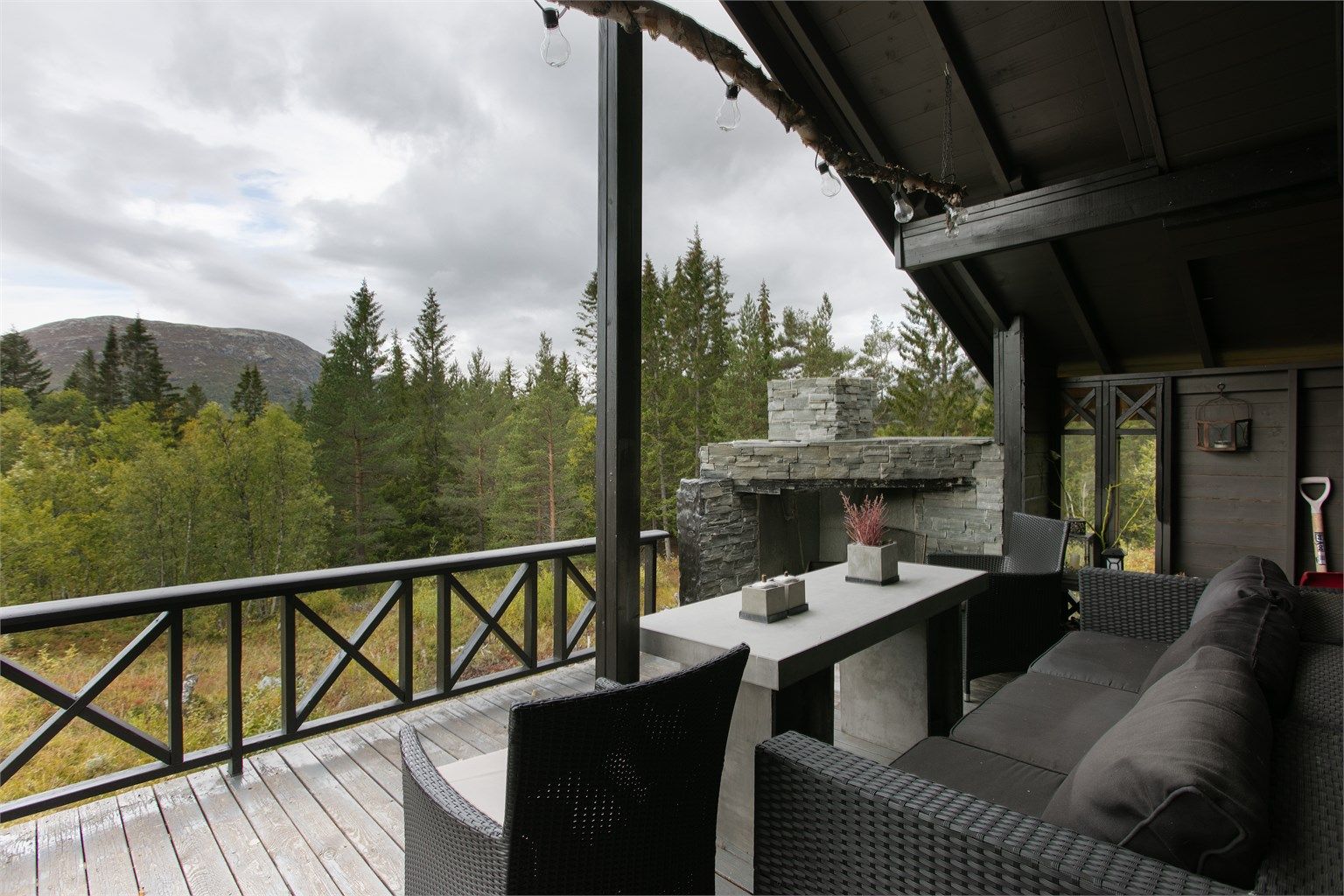 Murt utepeis i naturstein under det overbygde taket på terrassen.