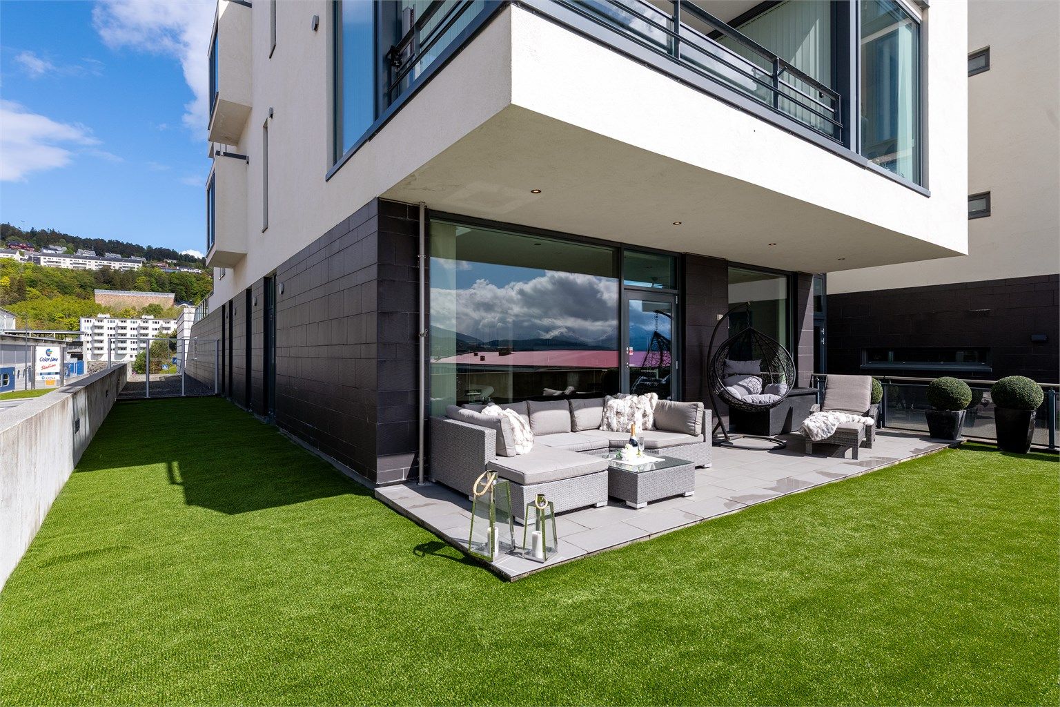 Solrikt uteareal på 91 m2 med fliser og kunstgress