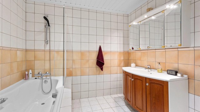 Badet i underetasjen er utstyrt med badekar og en romslig baderomsinnredning.