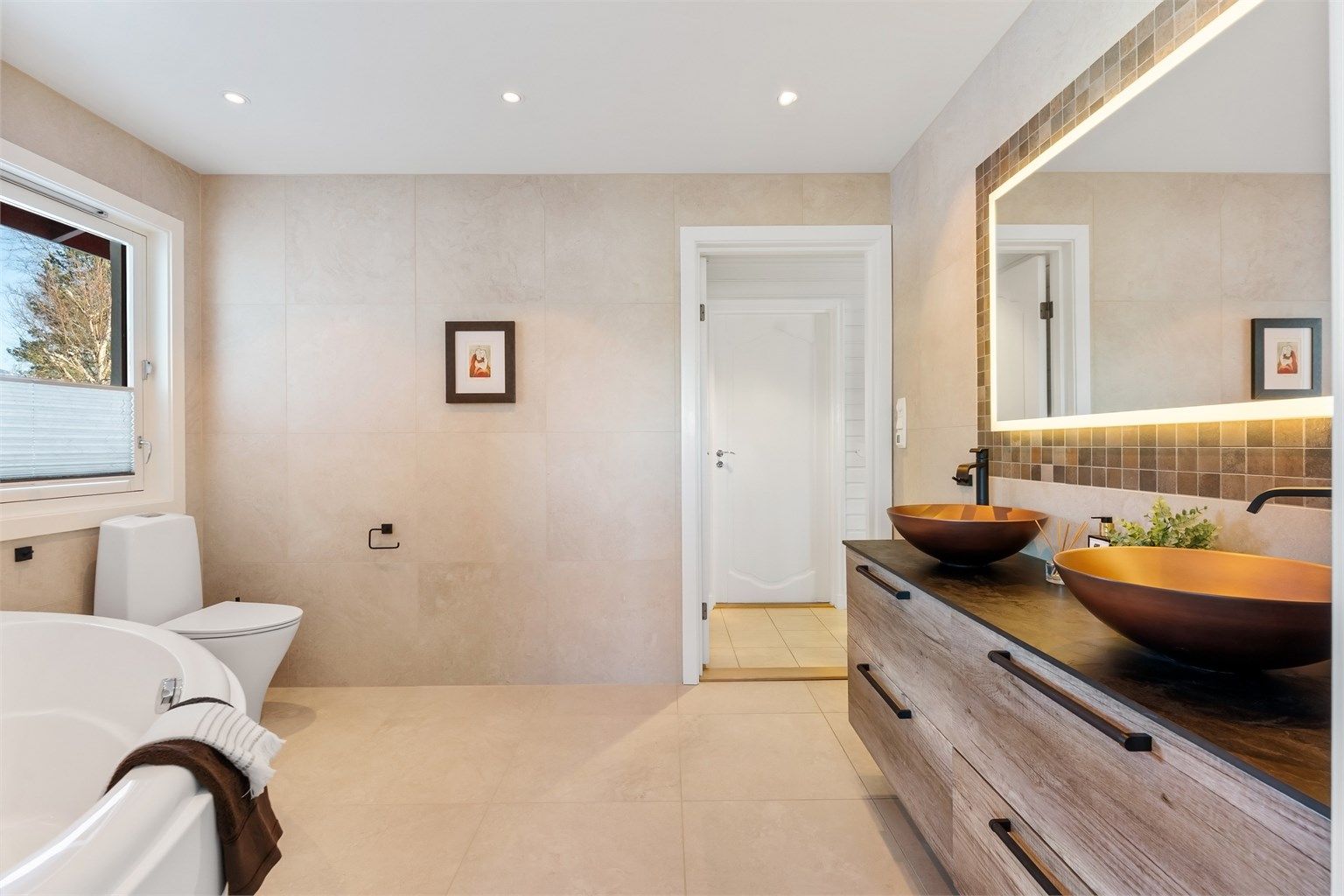 Rommet har flislagt gulv med gulvvarme og flislagte vegger.