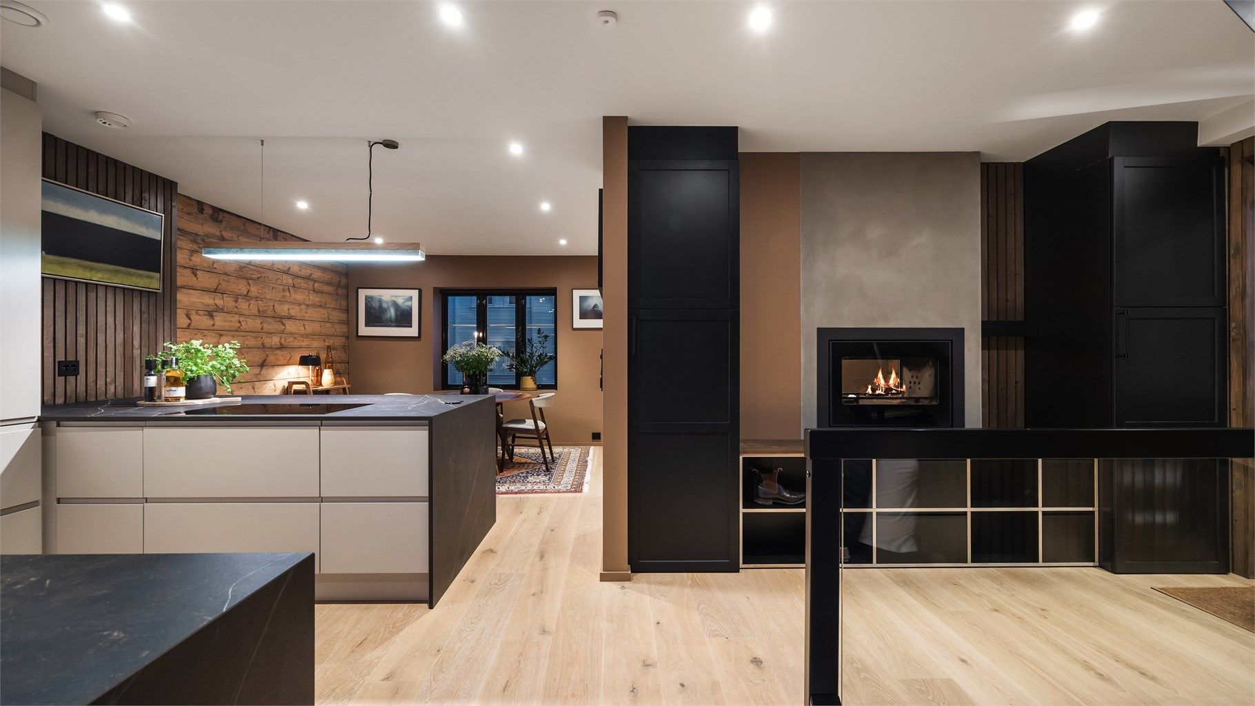 Hele etasjen fremstår innbydende med en smart plassert gjennomgående vedovn som man kan se fra både kjøkken og stue. 