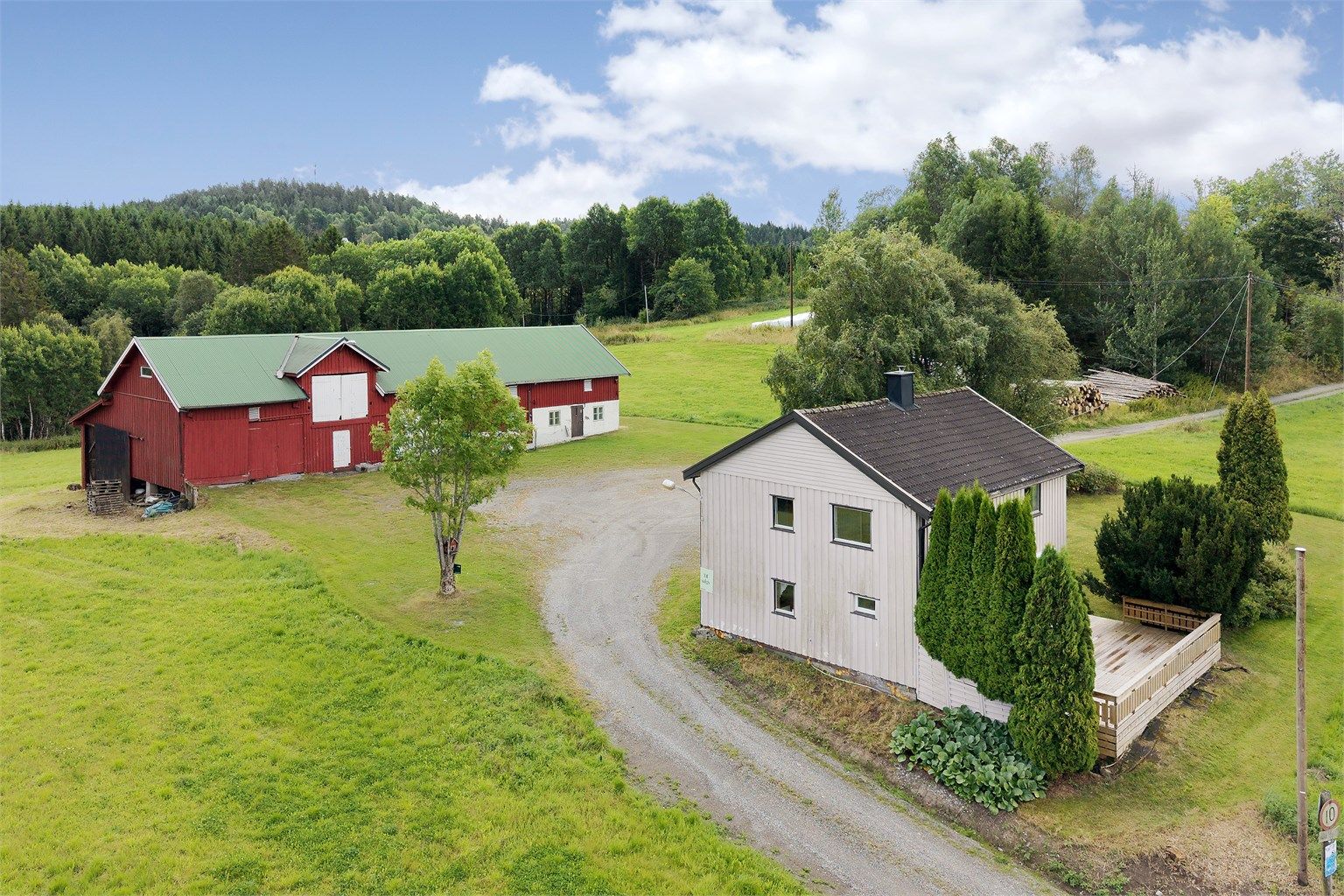 Eiendommen sett fra siden, med terrassen vendt mot jordene.