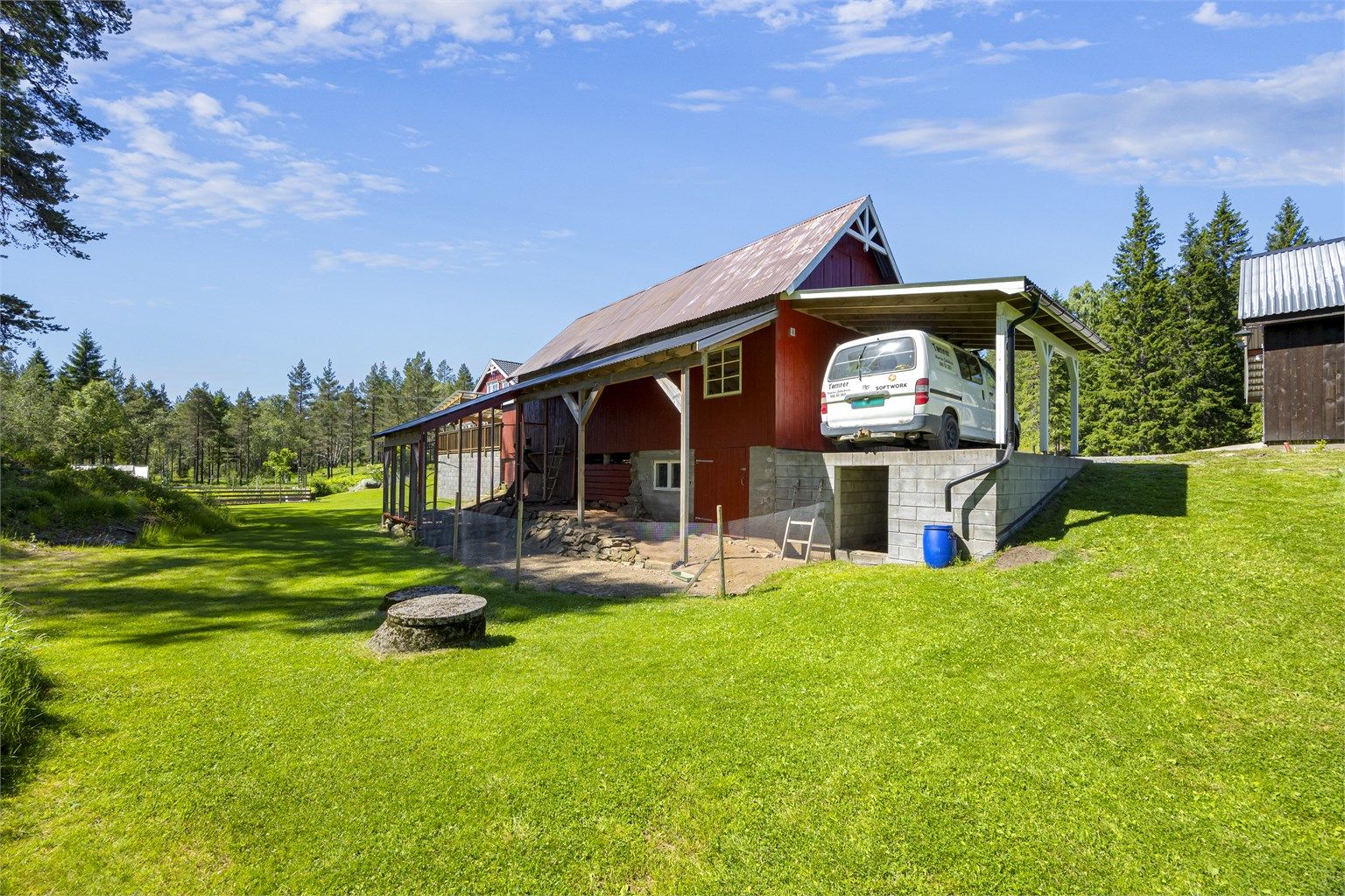 Eiendommen inkluderer en romslig låve med tilhørende hønsegård, carport og smøregrav.