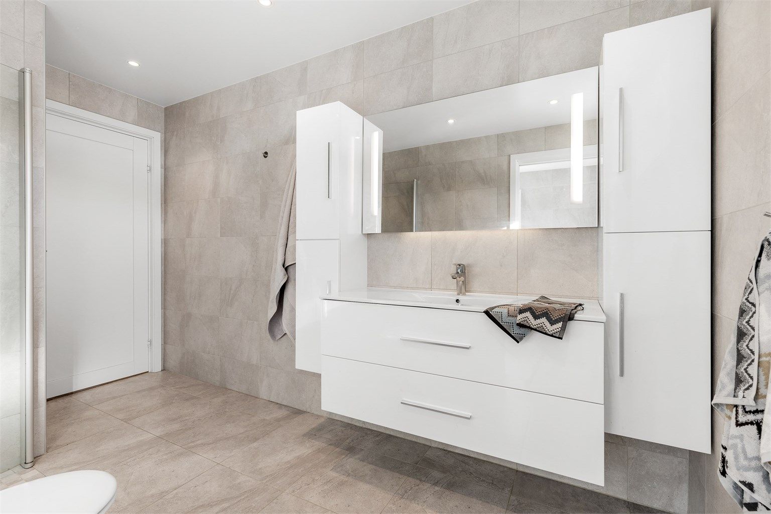 Lyst og moderne bad i underetasjen med downlights i tak samt varmekabler i gulv