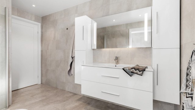 Lyst og moderne bad i underetasjen med downlights i tak samt varmekabler i gulv