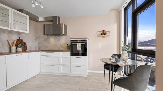 Kjøkkenet er utstyrt med integrerte hvitevarer som stekeovn, platetopp, oppvaskmaskin og kjøleskap med fryser