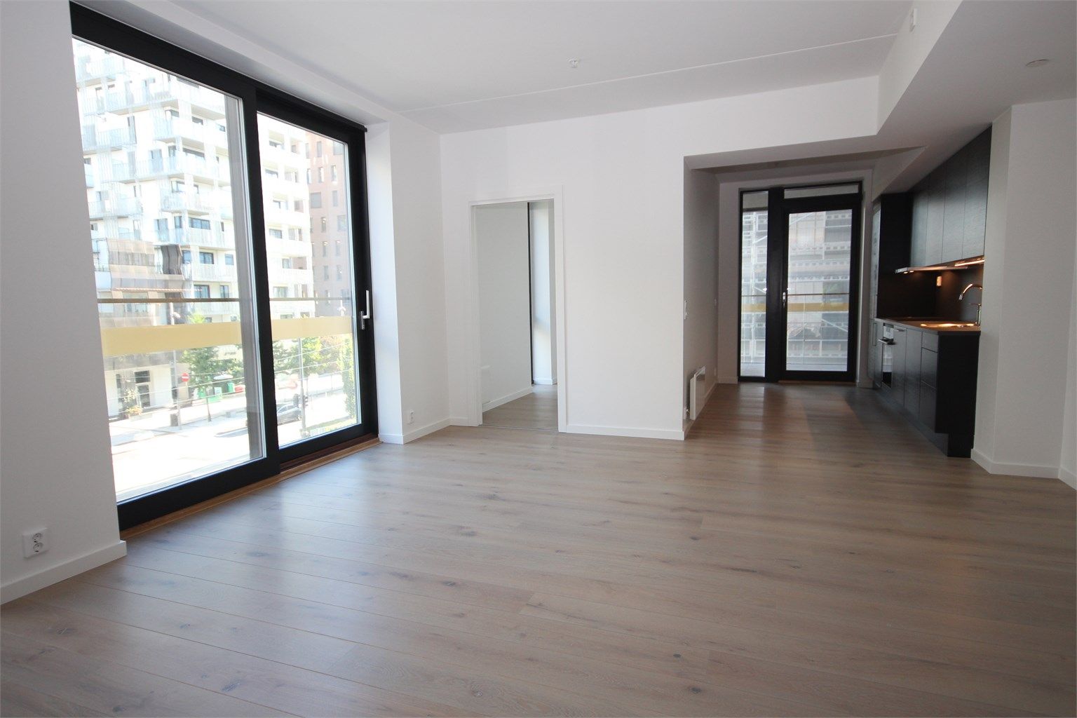 Stue med store vinduer og skyvedør med fransk balkong.