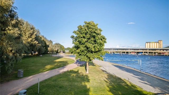 Pent opparbeidet strandpromenade med grøntområder, lekeplasser, volleyballbane og badeplass.