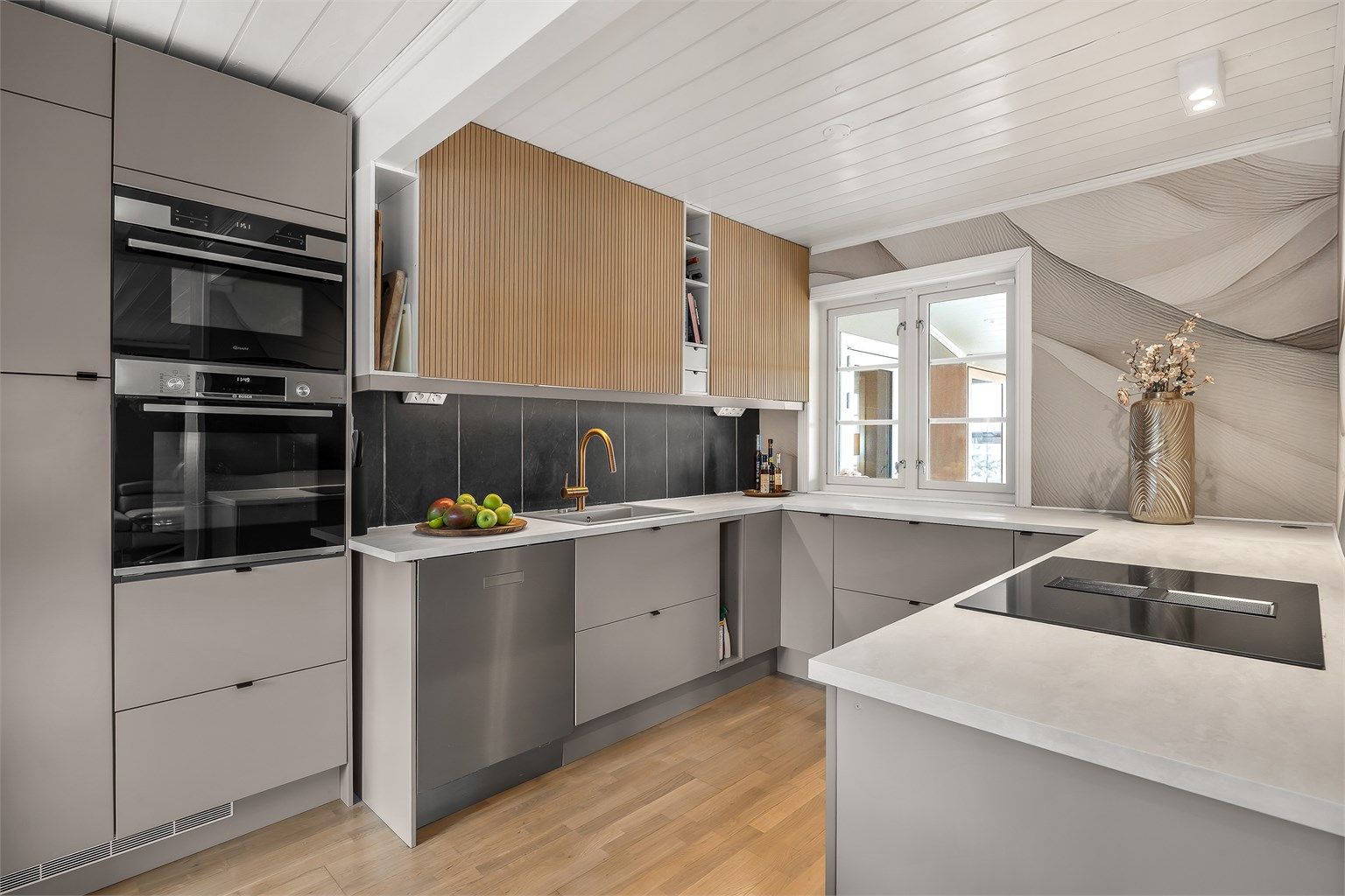 Kjøkkeninnredningen har glatte fronter og delvis integrerte hvitevarer.