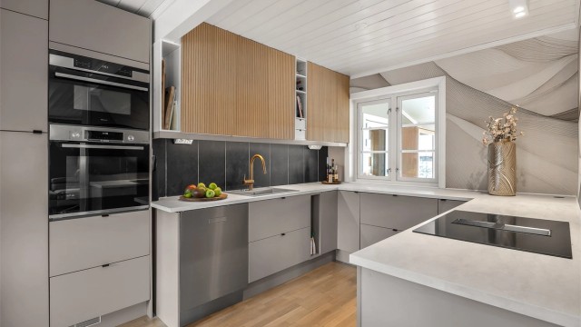 Kjøkkeninnredningen har glatte fronter og delvis integrerte hvitevarer.