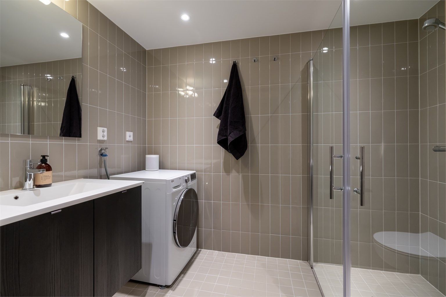 Leilighetens andre bad ligger i tilknytning til entréen og er flislagt med gulvvarme.