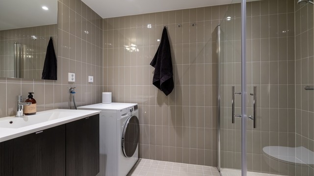 Leilighetens andre bad ligger i tilknytning til entréen og er flislagt med gulvvarme.