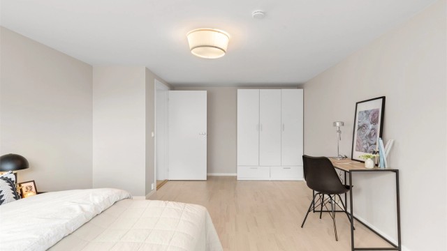 Rommet har god plass til dobbeltseng, garderobeskap og en arbeidsplass