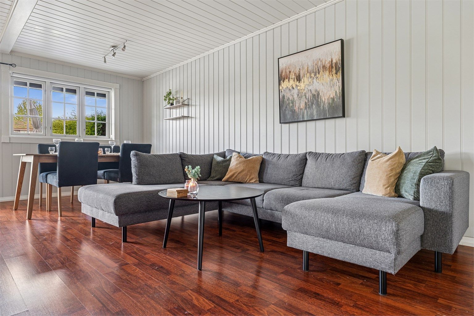 Stuen er lys og romslig med plass til stor sofa og spisestue