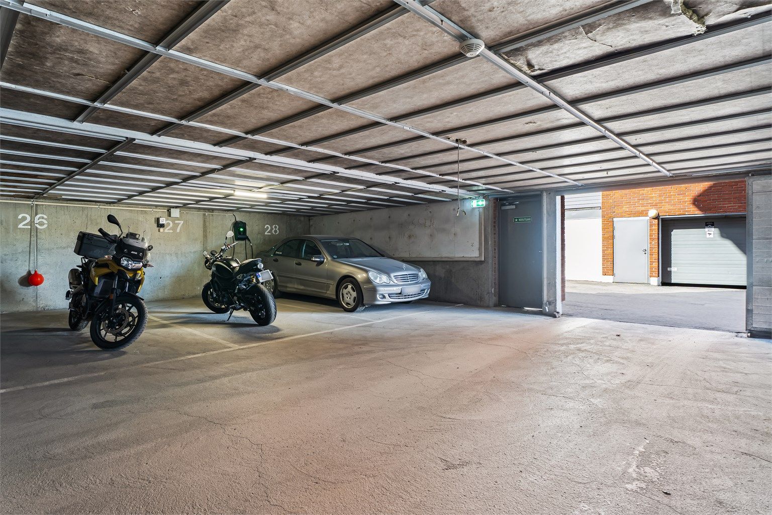 Leiligheten disponerer en garasjeplass (nr.27) i felles garasjekjeller med heisadkomst. Mulighet for å montere elbil-lader. 