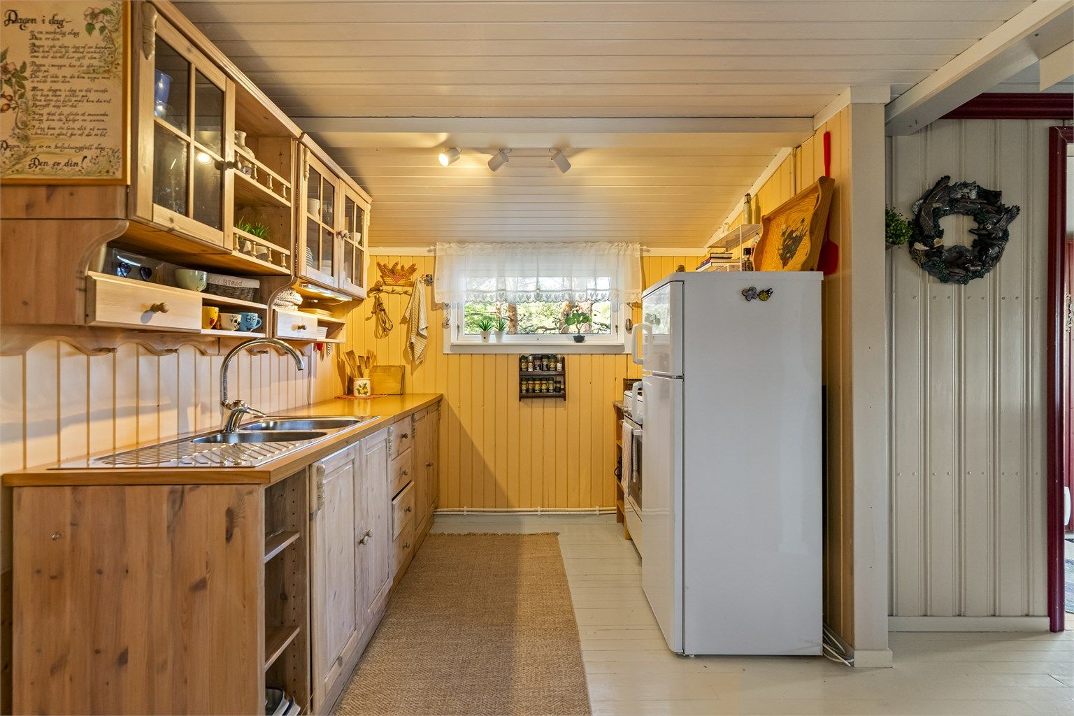 Kjøkkeninnredning fra 2000 med profilerte fronter og benkeplate i laminat.