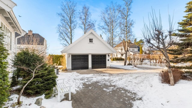 Frittstående dobbelgarasje på 38 kvm og med loftetasje på 18 kvm (loftetasjen har gulvareal på 45 kvm). Elektrisk garasjeport og elbillader på yttervegg. "Smørebod" i garasjen med oppvarming