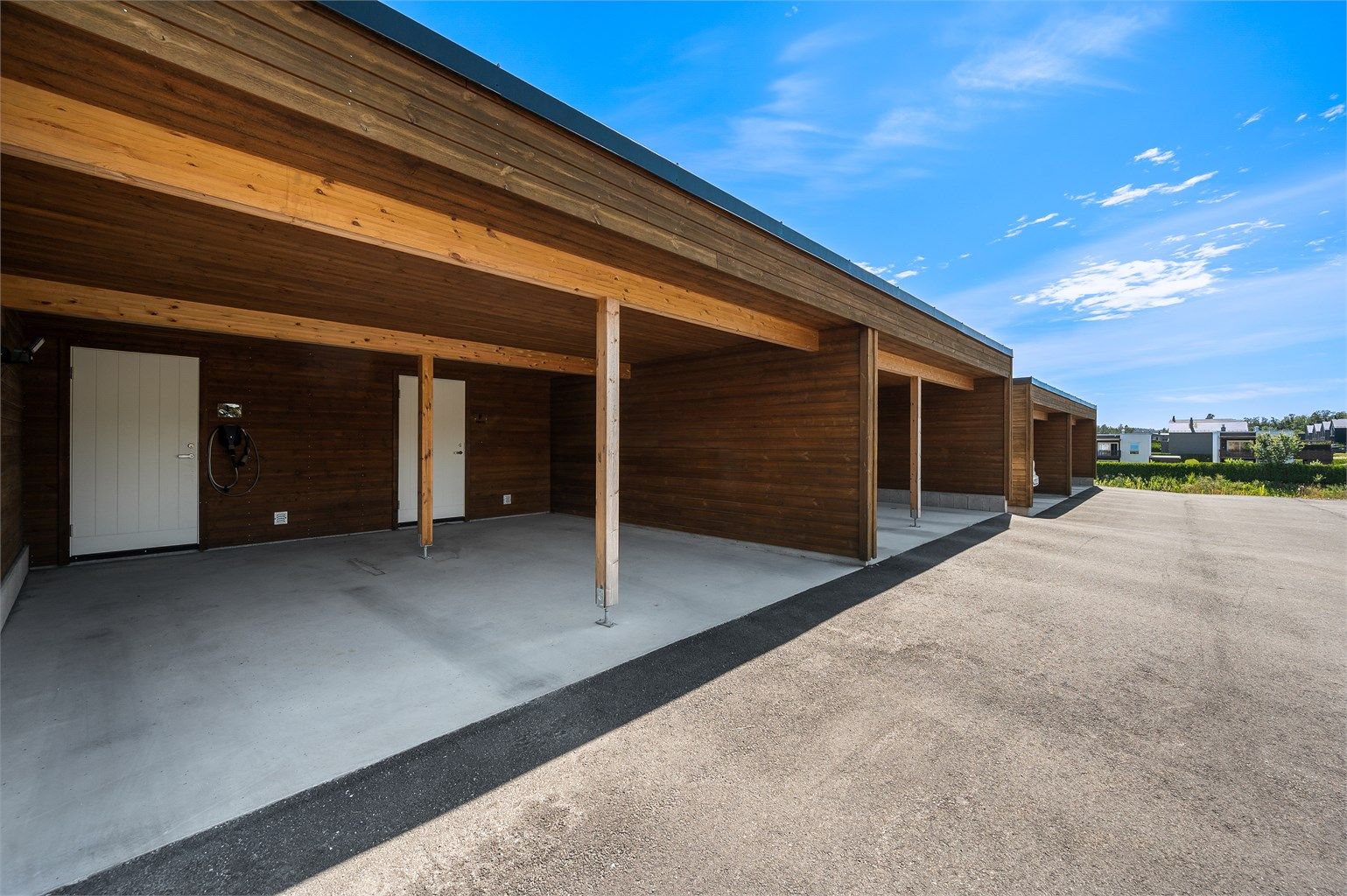 Parkering i carport med tilhørende utvendig sportsbod og elbillader.