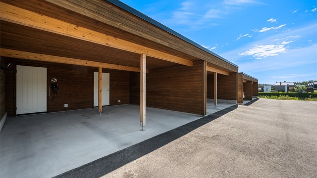 Parkering i carport med tilhørende utvendig sportsbod og elbillader.