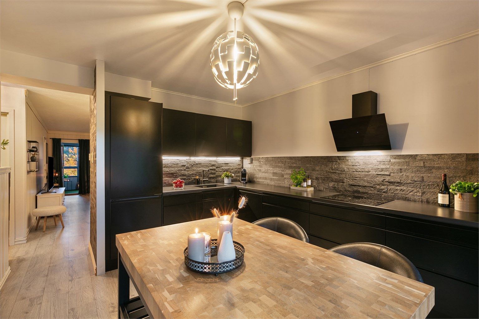 Romslig og moderne kjøkken fra 2019 med stilrene, sorte fronter.