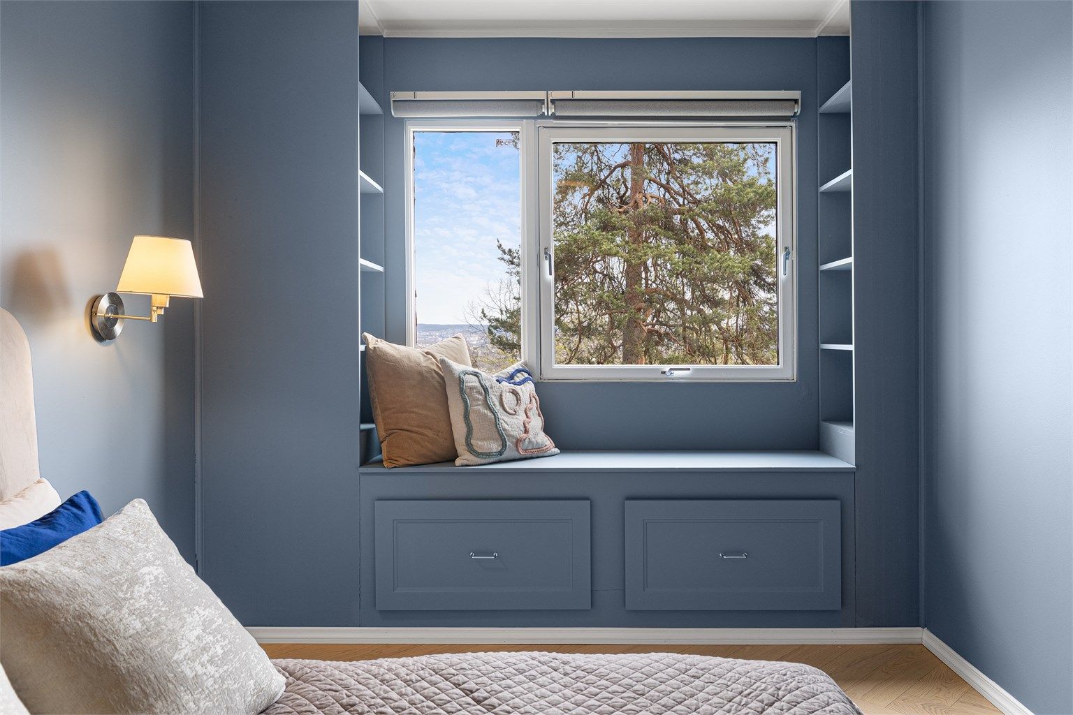 Vindusbenken er en sjarmerende detalj som gir en hyggelig lesekrok og skjult oppbevaring i skuffene under.